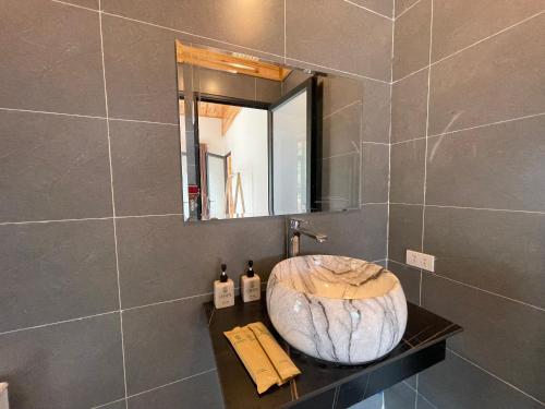 a bathroom with a large stone sink and a mirror at Nhà Bên Suối homestay in Sa Pa