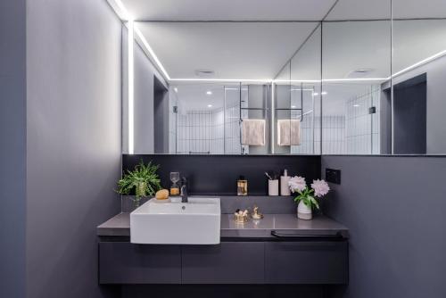 a bathroom with a sink and a mirror at Stey Beijing Sanlitun Boutique Hotel in Beijing