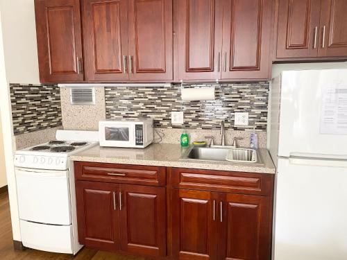 a kitchen with wooden cabinets and a sink and a microwave at Free parking Comfy central Waikiki in Honolulu