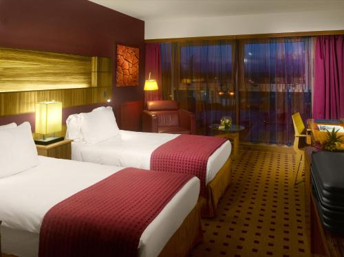 a hotel room with two beds and a chair at Radisson Blu Hotel, Cork in Cork