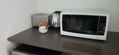 a microwave sitting on top of a wooden counter at Karuah Gardens Motel in Karuah