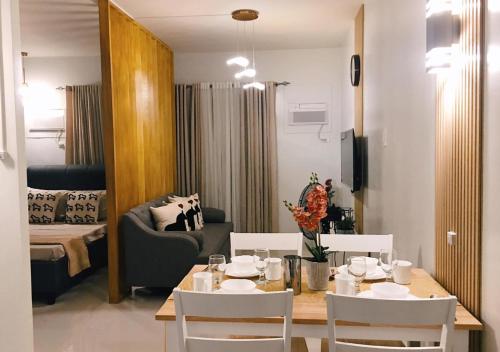 a room with a table and chairs and a living room at Palawan Luxury Stay with Balcony, Free Gym & Pool - B1 5Topaz in Puerto Princesa City