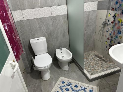 a bathroom with a toilet and a shower and a sink at Home Anxhelo in Durrës