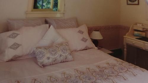 a bedroom with a bed with white sheets and pillows at Poihipi Farm Stay 
