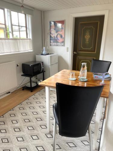 a dining room with a wooden table and chairs at beach room in Snogebæk