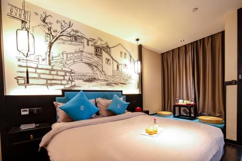 um quarto com uma cama grande e almofadas azuis em Xijian Hotel - Kunming Dongfeng East Road Dashuying Metro Station em Kunming