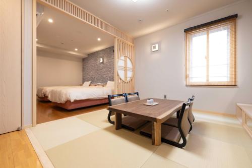 a bedroom with a bed and a table and chairs at Bell's Inn Tsuchiura in Tsuchiura