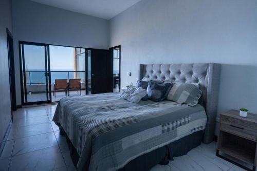 1 dormitorio con 1 cama grande y balcón en Casa Shalom, en Maneadero