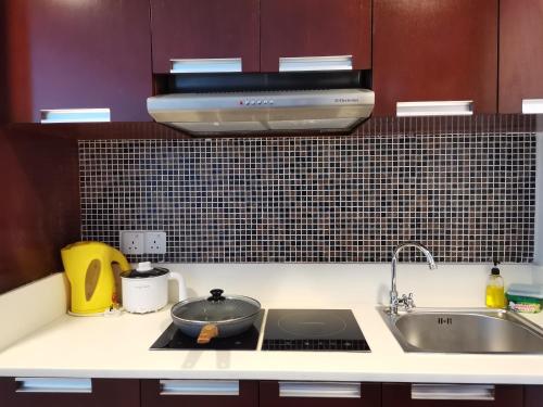 a kitchen with a sink and a stove top oven at Greenage MingSuite 明绿时代套房 Kota Kinabalu 亚庇市中心 in Kota Kinabalu
