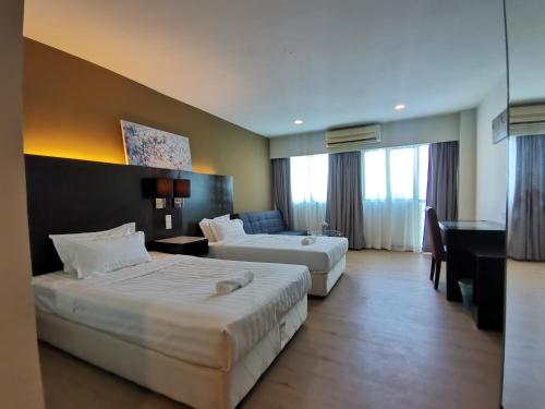 a hotel room with two beds and a desk at Greenage MingSuite 明绿时代套房 Kota Kinabalu 亚庇市中心 in Kota Kinabalu
