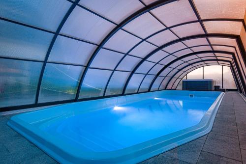 央塔的住宿－OSADA JANTAR 2，一座带玻璃天花板的建筑中的室内热水浴池