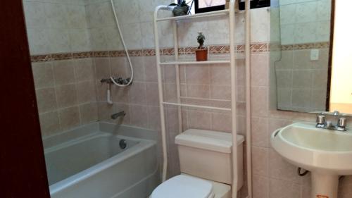 a bathroom with a toilet and a sink and a shower at Preciosa casa colonial in Quito