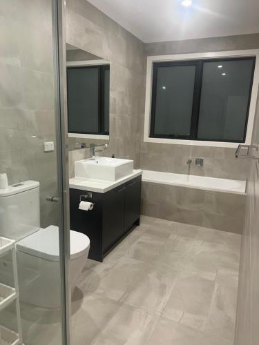 uma casa de banho com um WC, um lavatório e um espelho. em Private Rooms in Clayton South Near Monash Uni em Clayton North