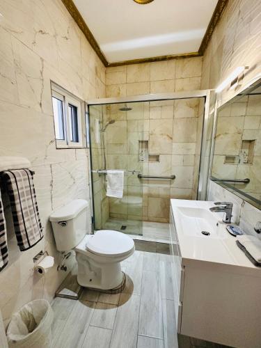 a bathroom with a toilet and a shower and a sink at Villa Panorama in Montego Bay