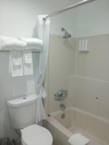 a white bathroom with a toilet and a bath tub at Quality Inn in Post Falls