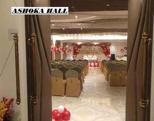 - une rangée de chaises dans une salle de banquet avec ballons rouges dans l'établissement Hotel Gold In Leaf, à Aligarh