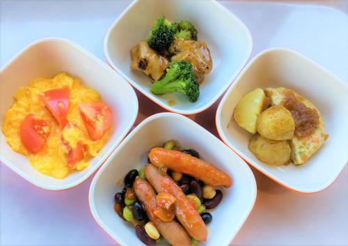 4 tazones de diferentes tipos de alimentos sobre una mesa en Select Inn Nagoya Iwakura Eki-mae en Iwakura