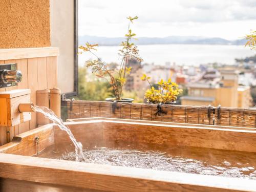 a bathroom sink with water coming out of a window at Yuzanso in Otsu