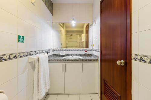 a bathroom with a sink and a mirror at Hotel La Cartuja in Quito