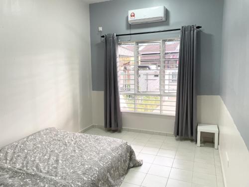 クアンタンにあるAl Kahfi Homestay @ Residensi PRIMA Gambangのベッドルーム(ベッド1台、窓付)