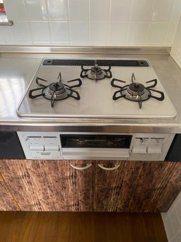 a stove top with two burners on it in a kitchen at Sun Sea GuestHouse in Yomitan