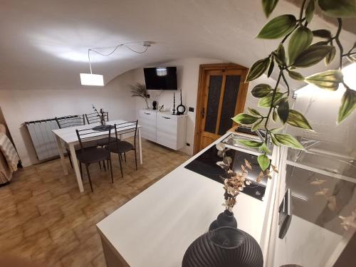 a kitchen and dining room with a white counter top at La casa del Gigante Frassino in Acceglio