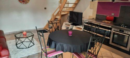 a living room with a table and chairs and a kitchen at Le Petit Nid in Saint-Loubès