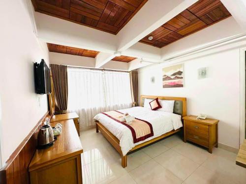 a bedroom with a bed and a television in it at Gold Dream Hotel in Da Lat