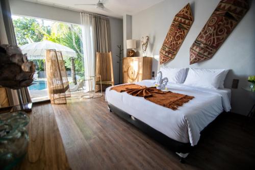 a bedroom with a bed and a large window at Villa Loba in Seminyak