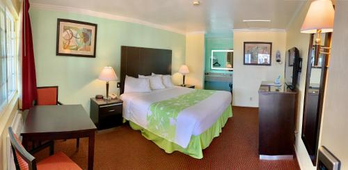 a hotel room with a large bed and a desk at Morro Bay Beach Inn in Morro Bay