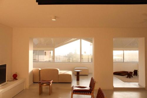 a living room with a couch and a tv at Mimizan Blue - Laid back luxury on the beach in Mimizan