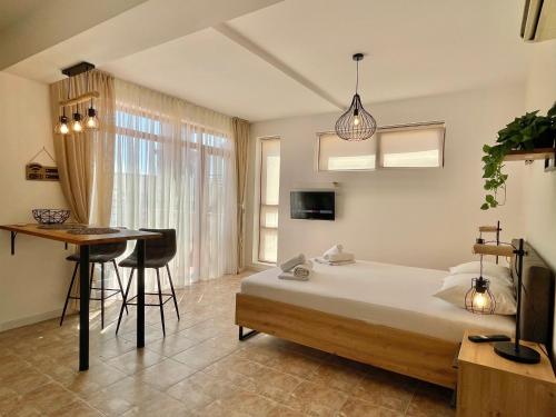 a bedroom with a bed and a table and a desk at Lighthouse - Private apartment - BSR - 4 in Sveti Vlas