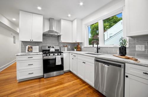 a kitchen with white cabinets and a stove top oven at Charming Room in Boston