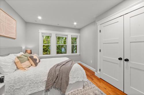 a white bedroom with a bed and windows at Charming Room in Boston