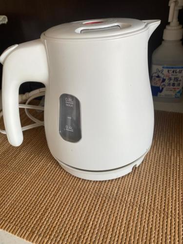 a white toaster sitting on top of a table at Sun Sea GuestHouse in Yomitan