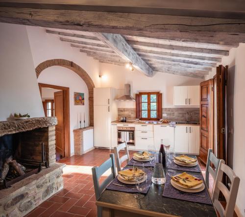 a kitchen and dining room with a table and a fireplace at CasaMoira in Trequanda
