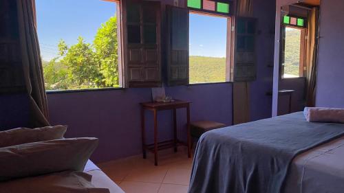 a bedroom with two beds and a window with a view at Pousada do Tom in Lençóis