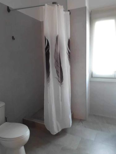 a bathroom with a toilet and a shower curtain at Seaside Serenade 2 suite in Ermoupoli