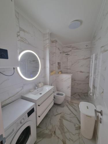 biała łazienka z umywalką i pralką w obiekcie Kumbor, Herceg Novi w mieście Kumbor