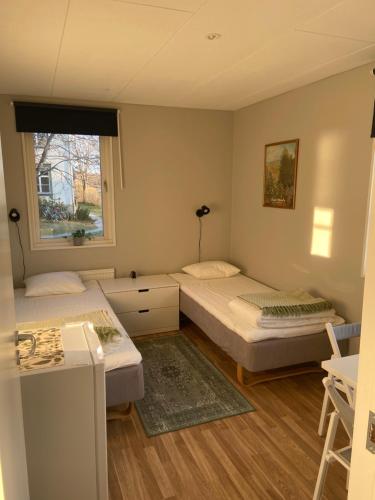 a room with two beds and a window at Sköna Rum Fryksta in Kil