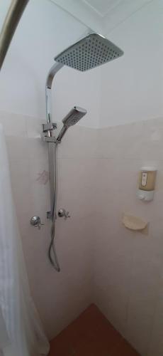 a shower with a shower head in a bathroom at Karuah Gardens Motel in Karuah