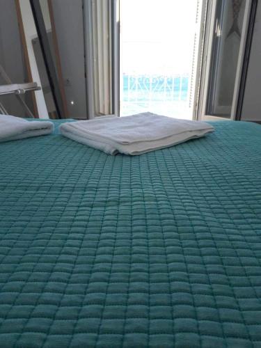 a bed in a room with a green mattress at Seaside Serenade 1, suite in Ermoupoli