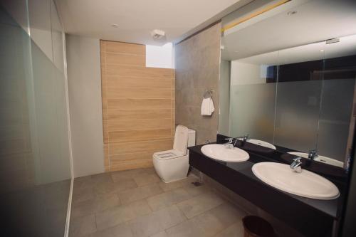 a bathroom with two sinks and a toilet at Giraffe Beach Hotel in Dar es Salaam