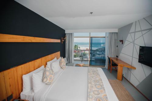 a bedroom with a bed with a view of the ocean at Giraffe Beach Hotel in Dar es Salaam