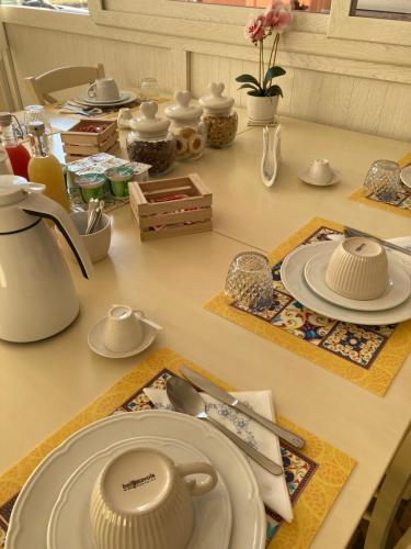 einen Tisch mit Tellern und Küchenutensilien auf der Theke in der Unterkunft B&B Orchidea in Gioia Tauro
