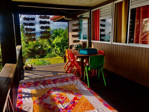 a quilt on a porch with a table and chairs at Fare Mirimiri in Uturoa
