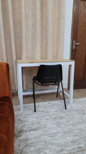 a black chair sitting in front of a white desk at Lux Suites Carina Casey Apartments Bamburi in Bamburi