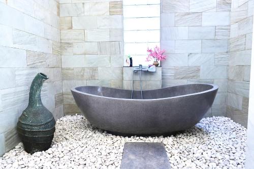 y baño con bañera grande sobre rocas. en Amour Eternel Villa, en Nusa Penida