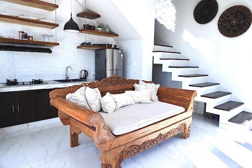 - un banc en bois dans une chambre avec des escaliers dans l'établissement Amour Eternel Villa, à Nusa Penida