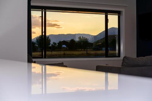 a living room with a view of the mountains through a window at 31 on Boundary in Twizel